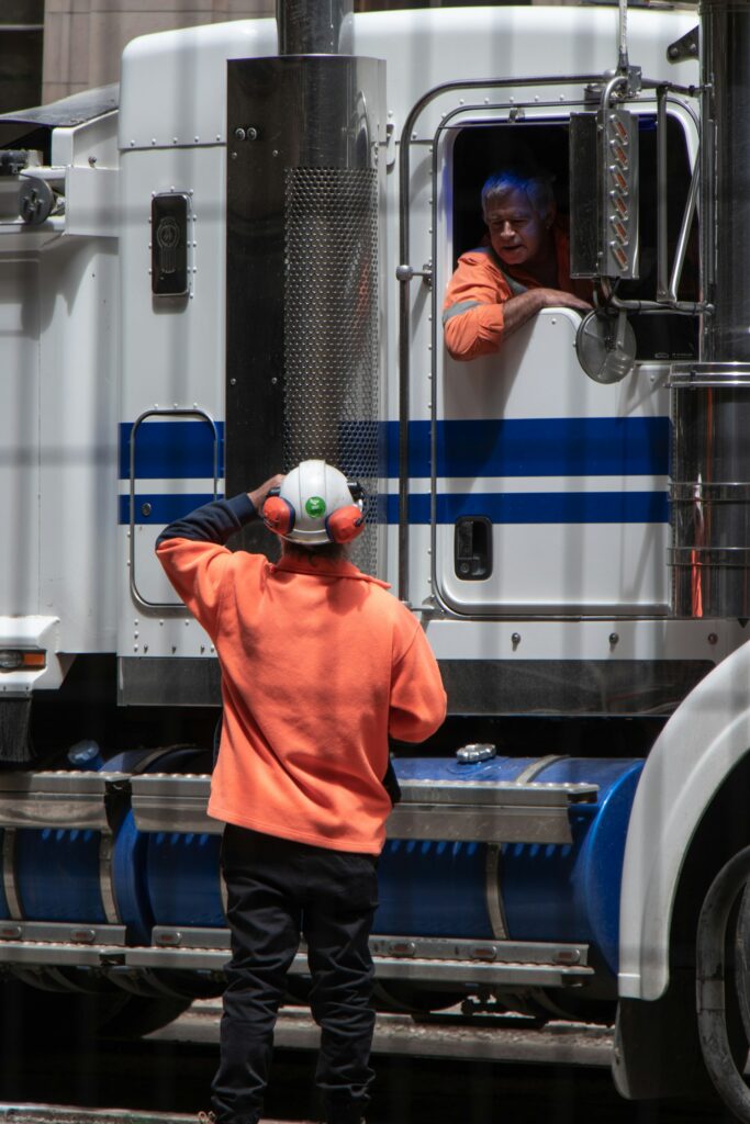 New truck driver standing in front of a freight truck