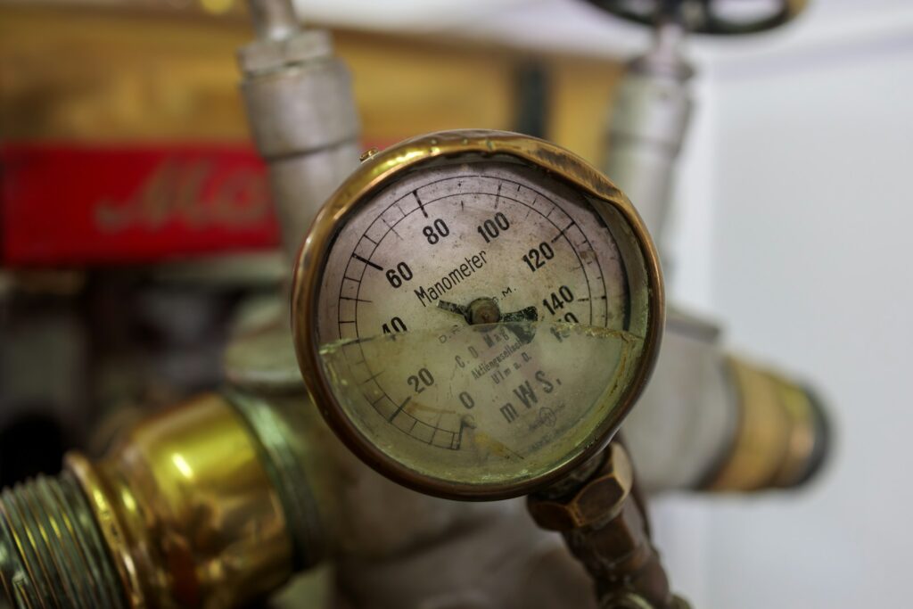 Close-up of a pressure gauge attached to a refrigerant pipe