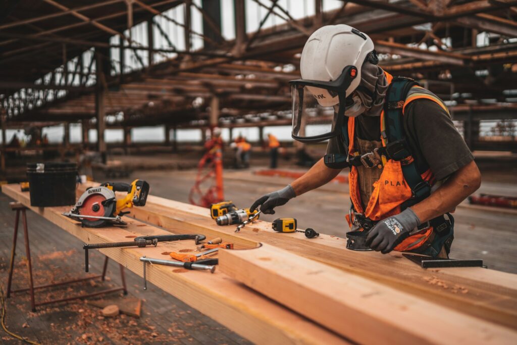 Construction apprentice in safety gear holding a power drill