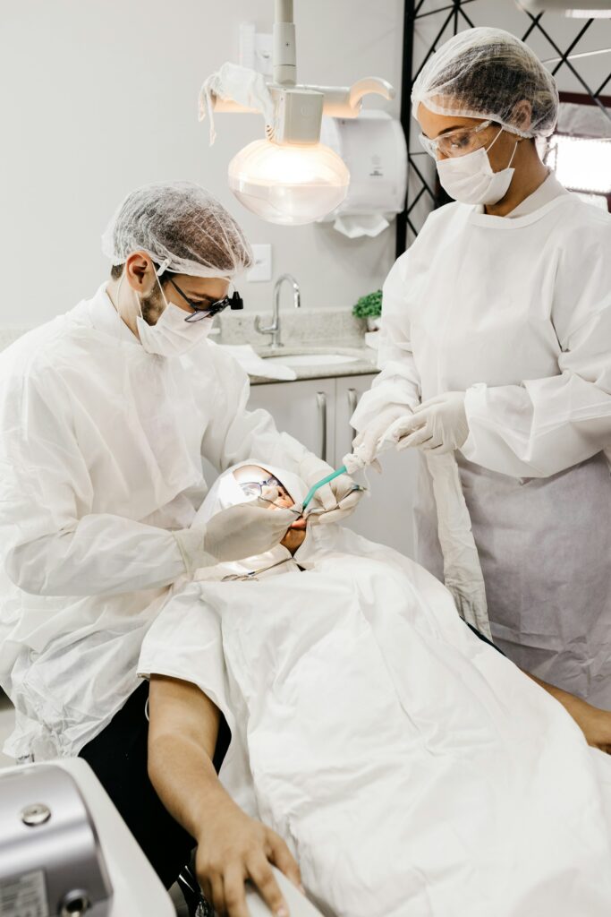 Dental team in protective gear treating a patient in a clinic