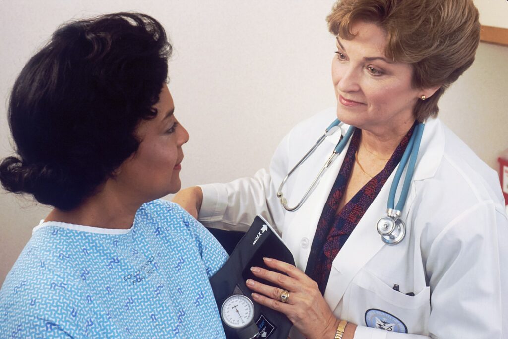 Nurse with a stethoscope talking with a patient