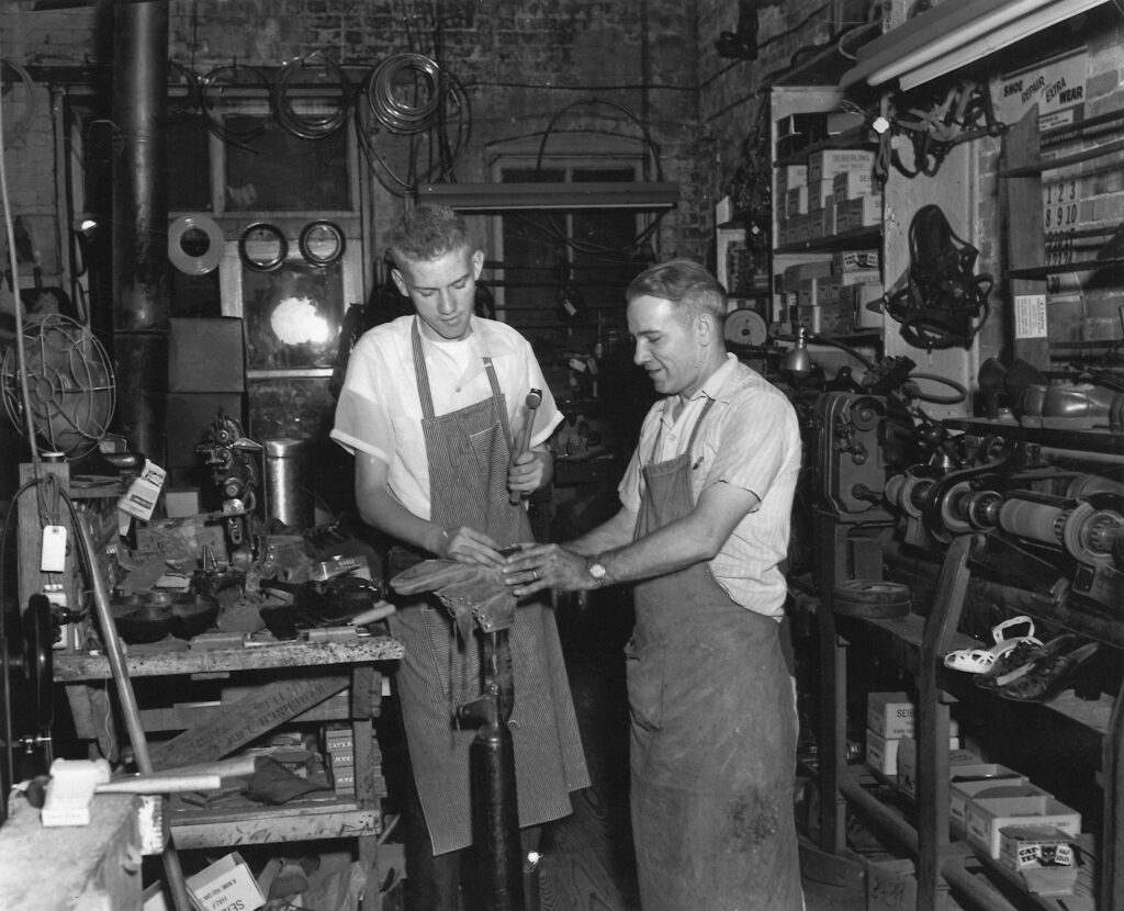 Experienced worker training an apprentice in a workshop